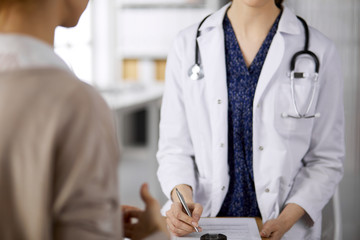 Doctor and patient discussing current health examination while sitting in clinic. Perfect medical...