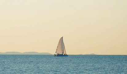 Fototapeta premium The sailboat is playing in the middle of the calm sea.
