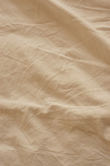 Detail of crumpled beige bed sheet texture