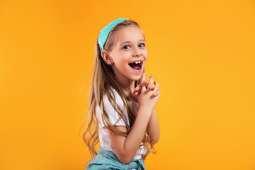 surprised little child girl in summer clothes on a colored yellow background. Vacation concept