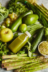Green antioxidant organic vegetables, fruits and herbs placed on gray stone