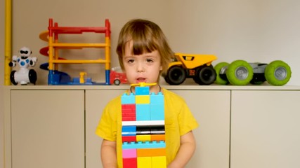 Cute boy demonstrates a tower toy made of blocks and talks about it for the Internet - Powered by Adobe