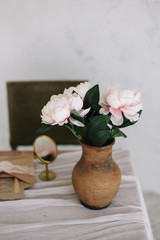 Romantic dressing table with a bouquet of peonies in a vase and a mirror. Bedroom interior in the vintage style. Boudoir. 