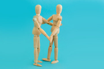 Couple in love, wooden two men holding hands on blue background. Symbol of family and friendship.