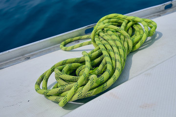 close up light green rope on board of yacht at summer sunny day. Yachting concept and blue sea...
