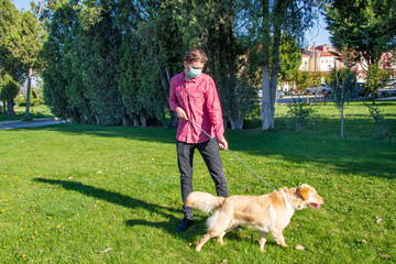 boy wearing virus mask   with his dog playing at garden