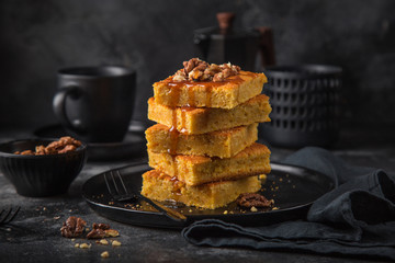 deelicious pumpkin squareswith nutsand caramel on dark background