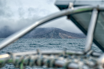 Sea landskape. View from sail boat to lighthouse at summer foggy day. Yachting concept and seascape...