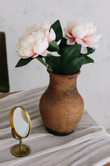 Romantic dressing table with a bouquet of peonies in a vase and a mirror. Bedroom interior in the vintage style. Boudoir. 
