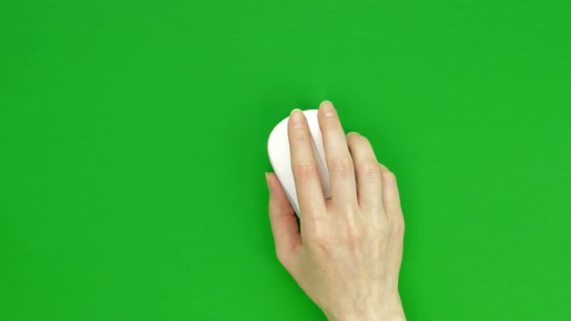 Female hand using, clicking, scrolling and tracking white computer mouse on green screen. Chroma key, top view.