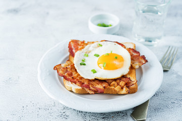Fried egg fried bacon sandwiches on a light background