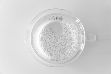 Soy Milk In The Measuring Cup On White Background 