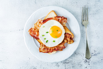 Fried egg fried bacon sandwiches on a light background