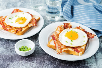 Fried egg fried bacon sandwiches on a light background