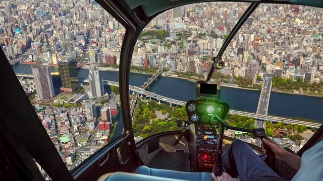 Time lapse of Tokyo city skyline with sumida river and asakusa area from helicopter cockpit inside the cabin flying on Tokyo cityscape. Sumida district, Japan. Sunny day in TIME LAPSE.