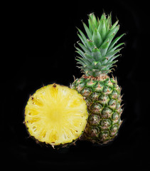 Fresh pineapple isolated on black background. Juicy pineapple. Fruits photo collection. One and half pineapple isolated on black background.