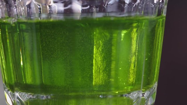 Drops of sugar drip into absinthe