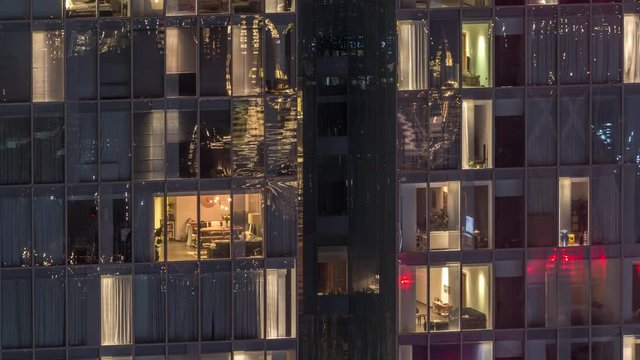 Night view of office and apartment building timelapse. High rise skyscraper with blinking windows with people moving inside. Aerial view from above