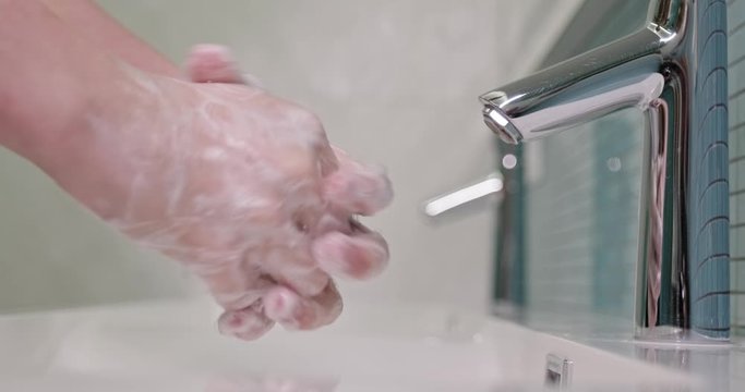 Coronavirus pandemic prevention wash hands with soap warm with  water.  Man rubbing fingers washing frequently and using hand sanitizer gel.