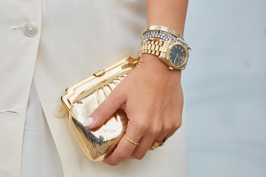 Woman with yellow gold Rolex Datejust and golden bag on September 21, 2016 in Milan, Italy