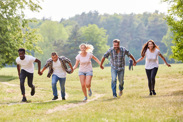 Freunde laufen zusammen über eine Wiese