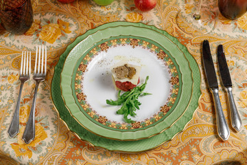 fish tartare with arugula, cheese and truffles on a green plate. top view