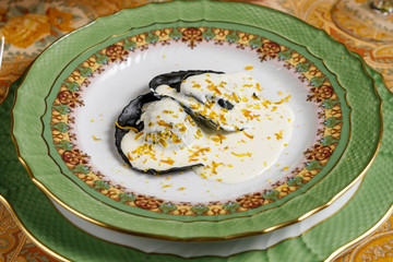 black ravioli with fish and sauce on a plate. top view