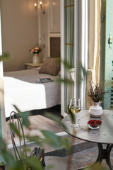 Beautiful view through the open balcony door to the interior of the bedroom, with a Cup of coffee standing on the bed, a newspaper and fresh croissants