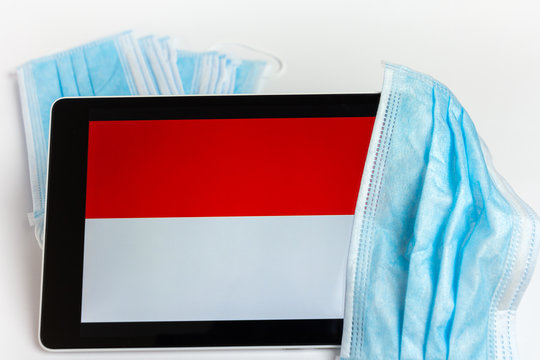 Indonesia flag covered by surgical protective mask for coronavirus COVID-19 prevention