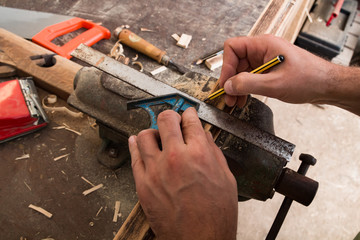 Male carpenter working on old wood in a retro vintage workshop.
