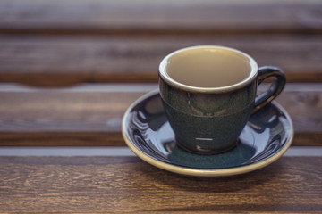 Colorful ceramic cup on wooden table for espresso