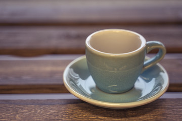 Colorful ceramic cup on wooden table for espresso
