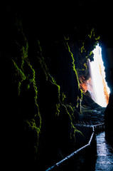 Interior of a huge cave behind a large waterfall