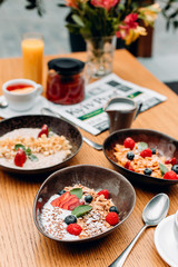 Cereal with milk with strawberries, raspberries and currants, black plate