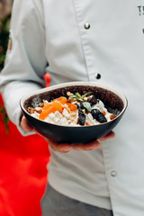 Cottage cheese with dried fruits and Basil on a black plate, dried apricots, raisins, prunes