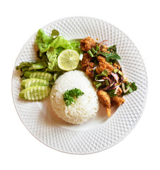 Pork fried rice on white plates. Cucumber slices are placed on a wooden table.