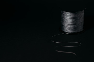 Thread on a bobbin on a black background