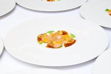 Close-up of a delicious ready-made dish of meat, corn and sauce in a round white plate on the table in a restaurant before dinner at a Banquet on a holiday