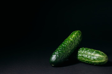 green cucumbers on a black background