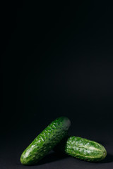 green cucumbers on a black background