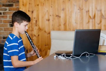Boy with a clarinet plays music. Online music lesson concept
