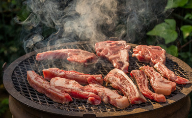 Fresh raw red meat grilled outdoors over an open fire image in horizontal format