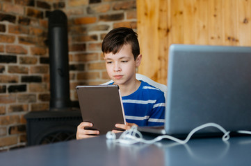 School kid using laptop while doing schoolwork at home. Homeschooling. School from home.