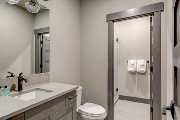 Natural new classic bathroom interior with new glass small walk in shower.