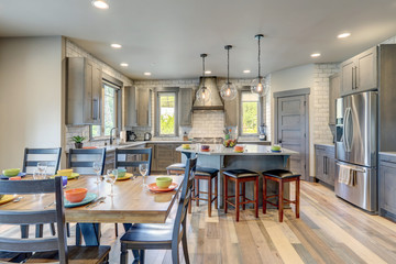 Absolutly stunning kitchen interior with grey tone of brown muted natural tones with light hardwood and white tile backsplash.