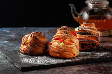 Kraffins with raisins, candied fruits and poppy seeds, sprinkled with powdered sugar.