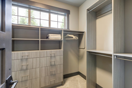 Natural new classic slick walk in closet room  interior with new grey wood shelves.