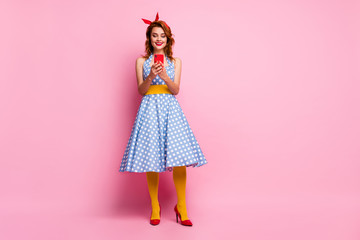 Full size photo of pretty beautiful lady hold telephone came retro theme party addicted smart phone wear dotted dress high-heels yellow tights isolated pink color background