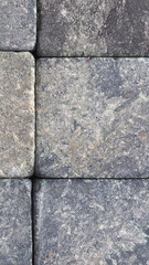 Stone background close-up. Natural texture. Light gray bluish backdrop or wallpaper. Rough surface. Reduced contrast. Vertical shot. Macro