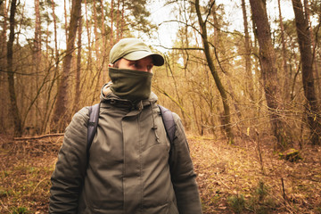 Fototapeta na wymiar A man with a covered face in the woods